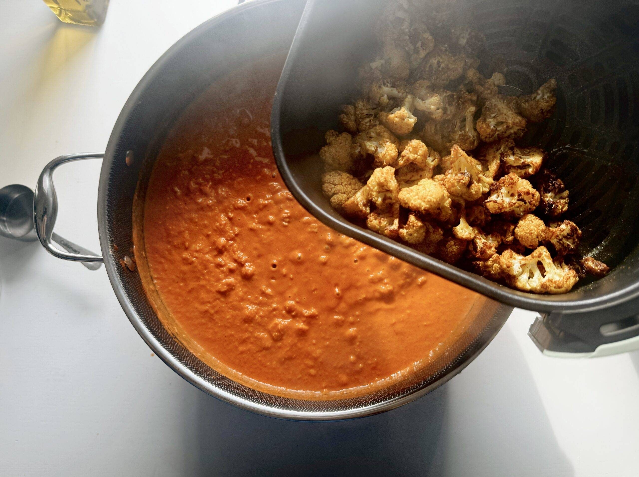 Adding cauliflower to pan.