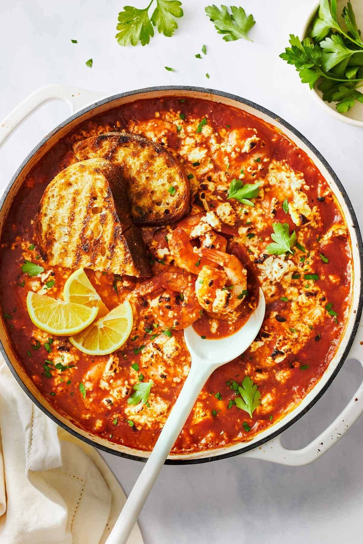 Shrimp and grilled bread in a skillet.