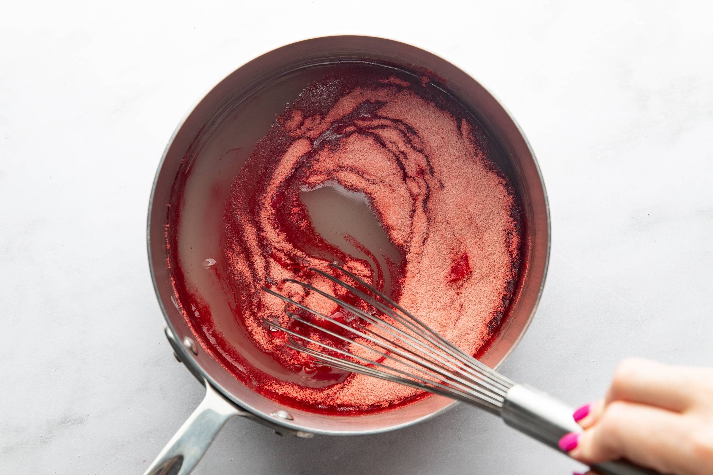 Whisking strawberry jello.
