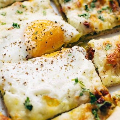Breakfast Pizza sliced with eggs.